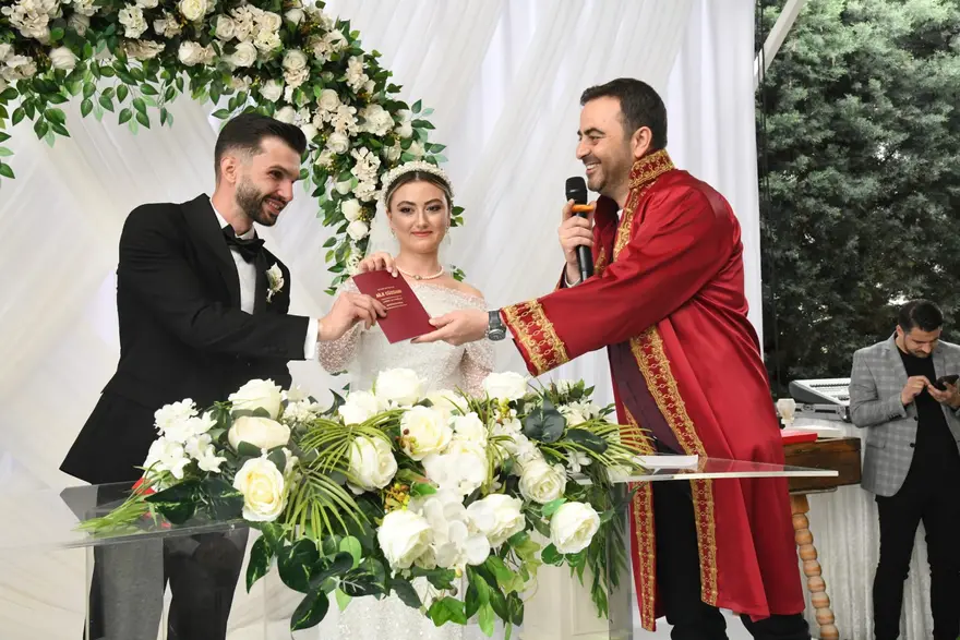 Başkan Özlü kırmızı cübbeyle bir çiftin nikâhını kıyıyor